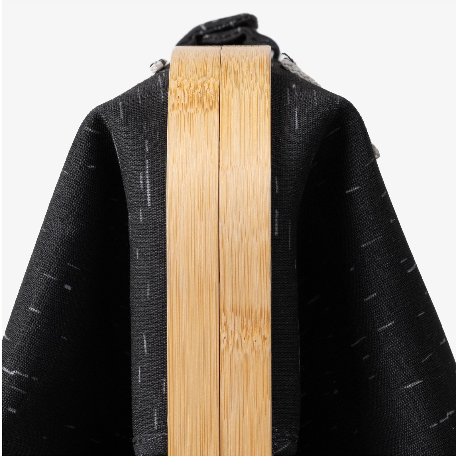 Close up of side view (with the wooden portion) of CleverMade laundry backpack LUXE