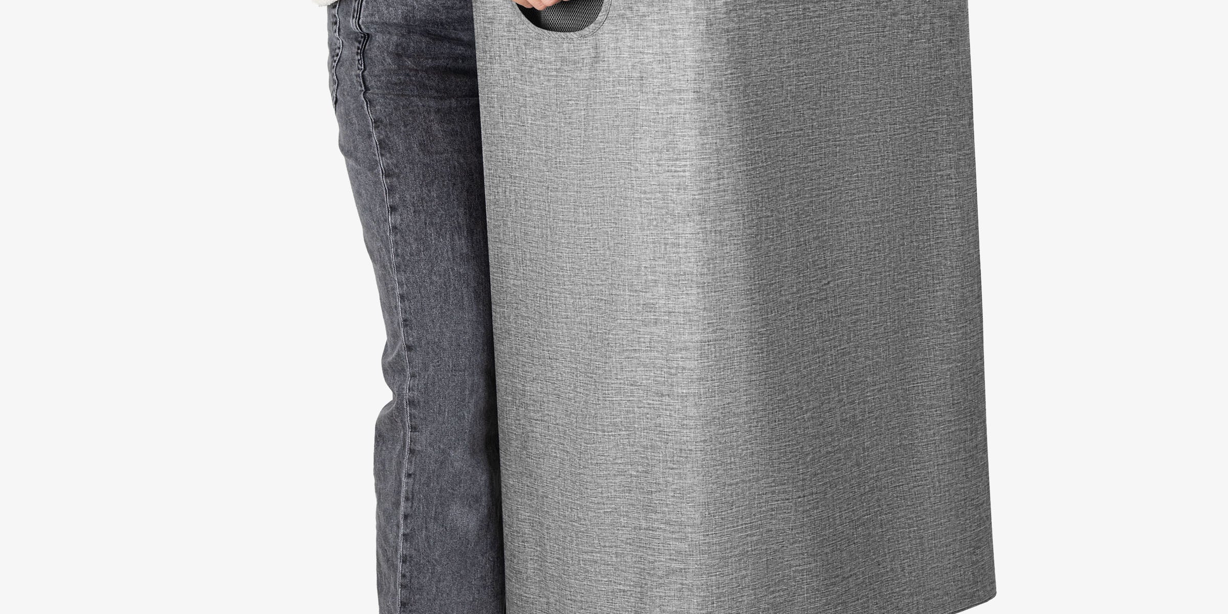 Person holding a large gray laundry basket on a white background