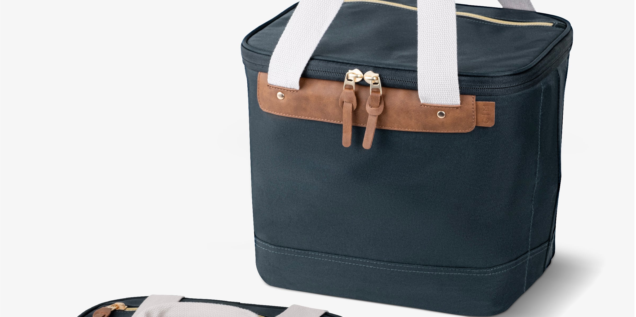 Malibu collapsible cooler bag with navy blue body, brown leather accents, and white straps.