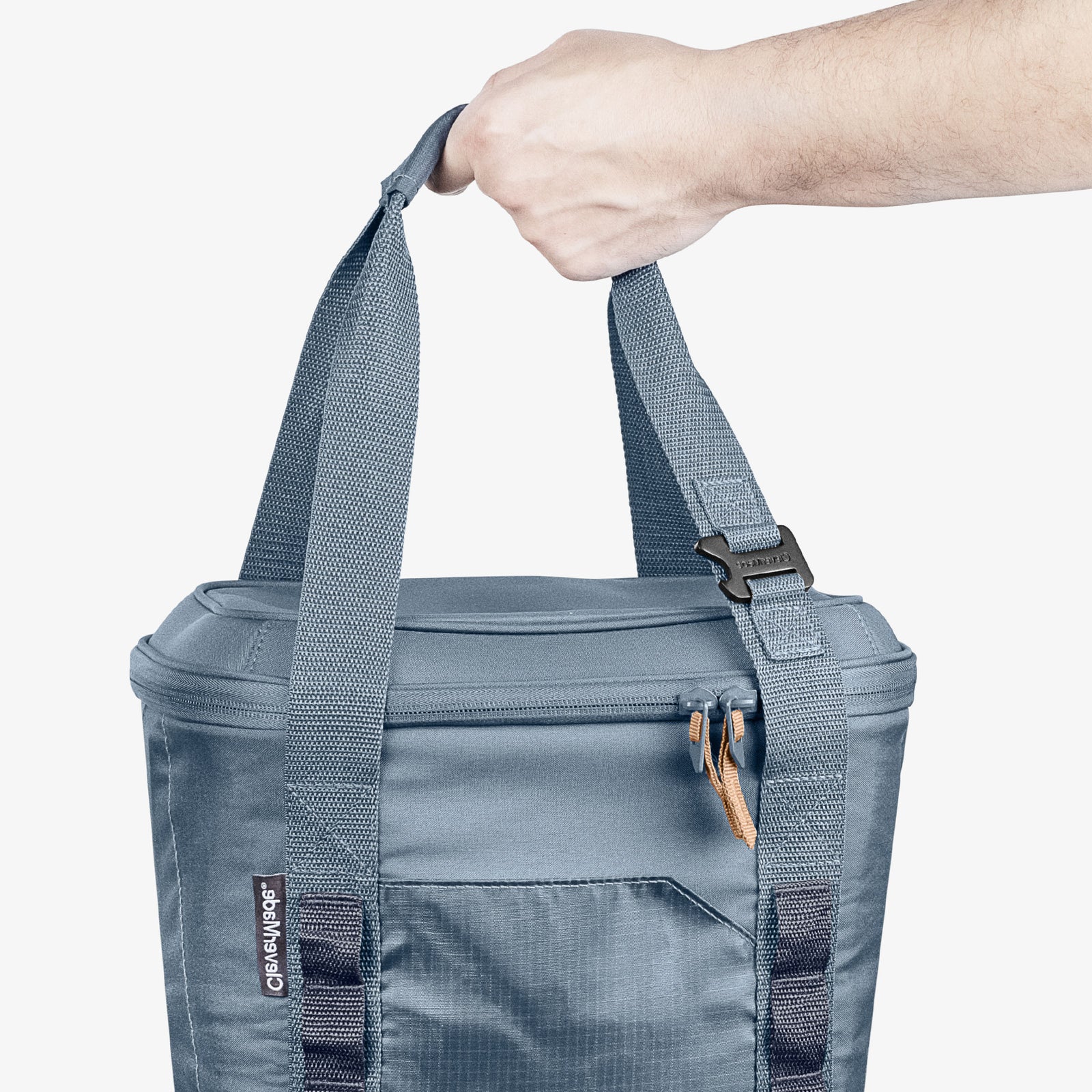Blue cooler bag with a hand holding its strap on a white background