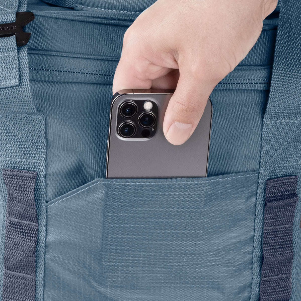 Hand placing a smartphone into a blue cooler bag pocket