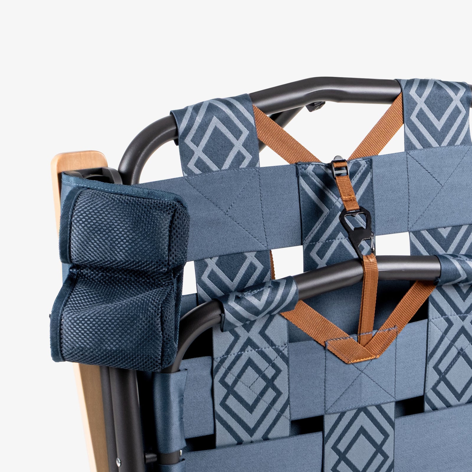 Folded Kove foldable outdoor chair with blue patterned backrest and brown straps on a white background on a white background