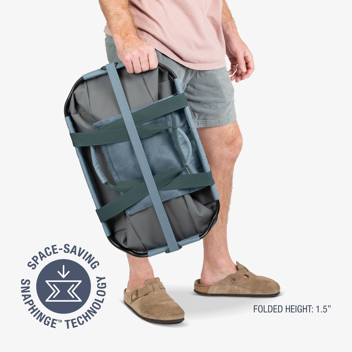 Person holding a compact gray bag with space-saving snapping technology on a white background