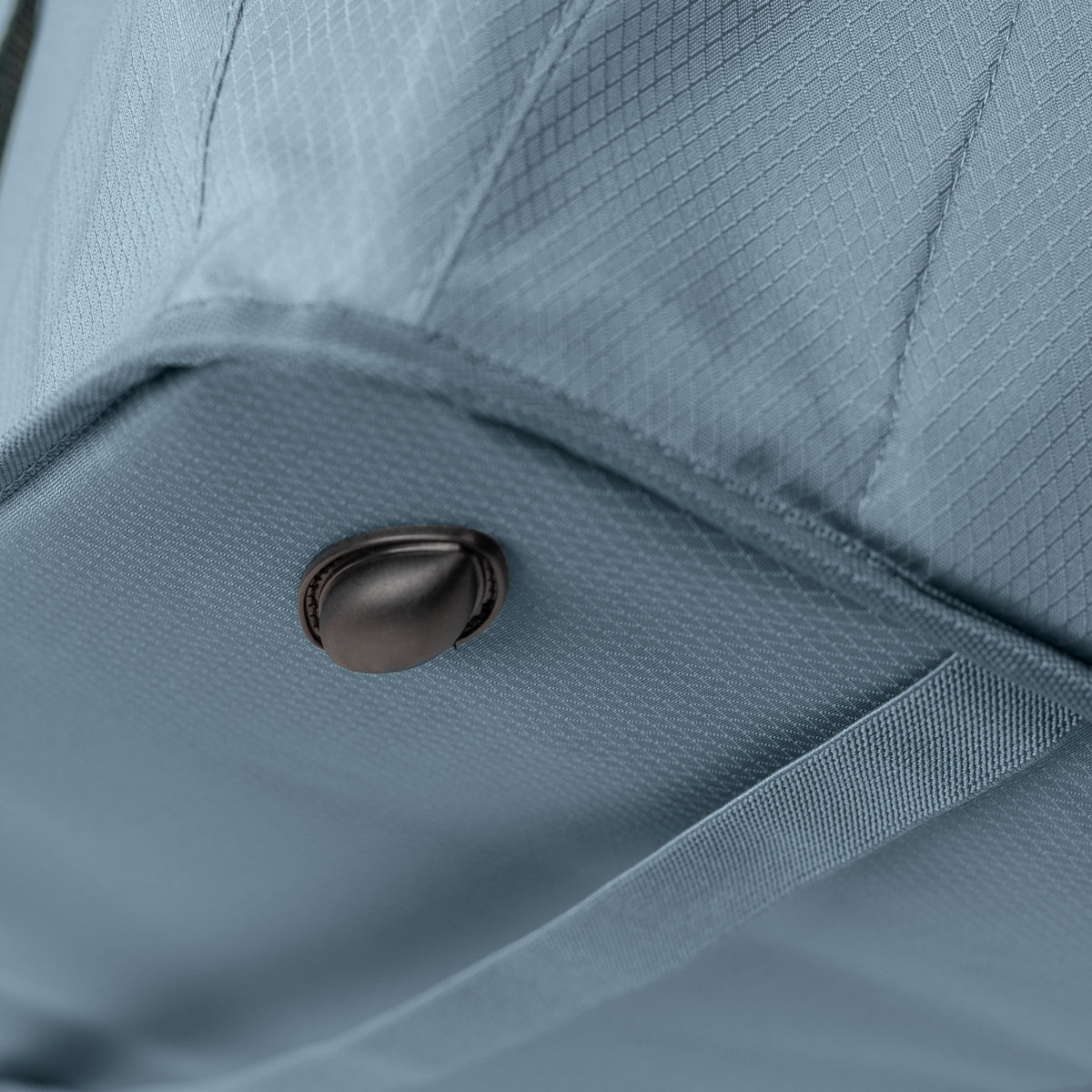 Close-up of a blue fabric with a button detail