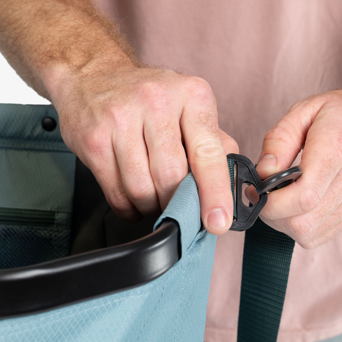 Person adjusting a car seat belt with a close-up of hands and seat.