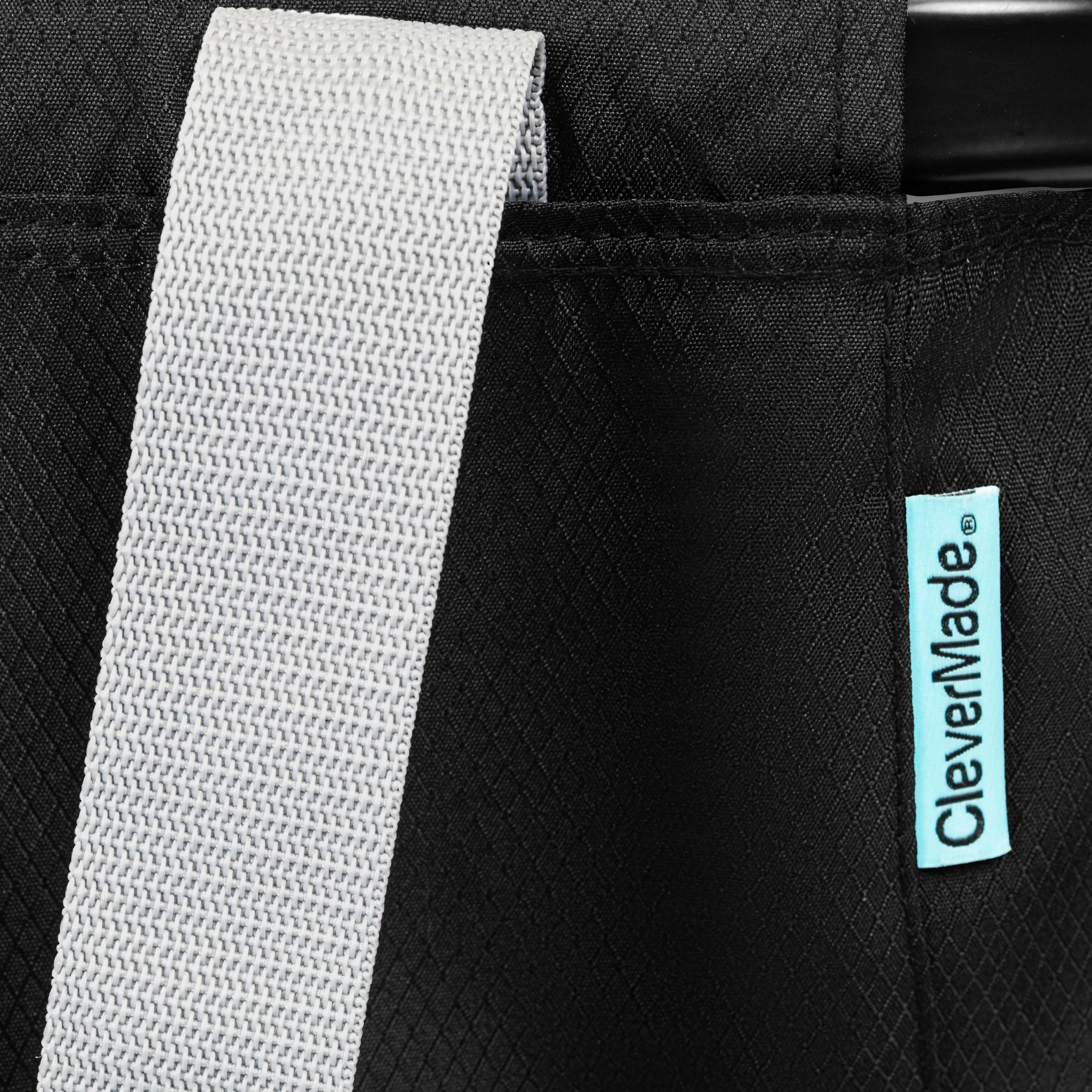 Close-up of a black bag with a gray strap and CleverMade logo.