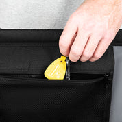 Person using a yellow tool to open a black bag