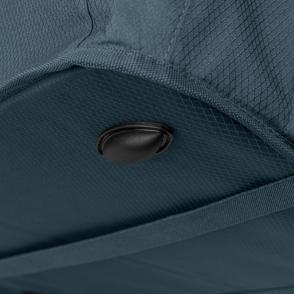 Close-up of a blue bag with a black button detail