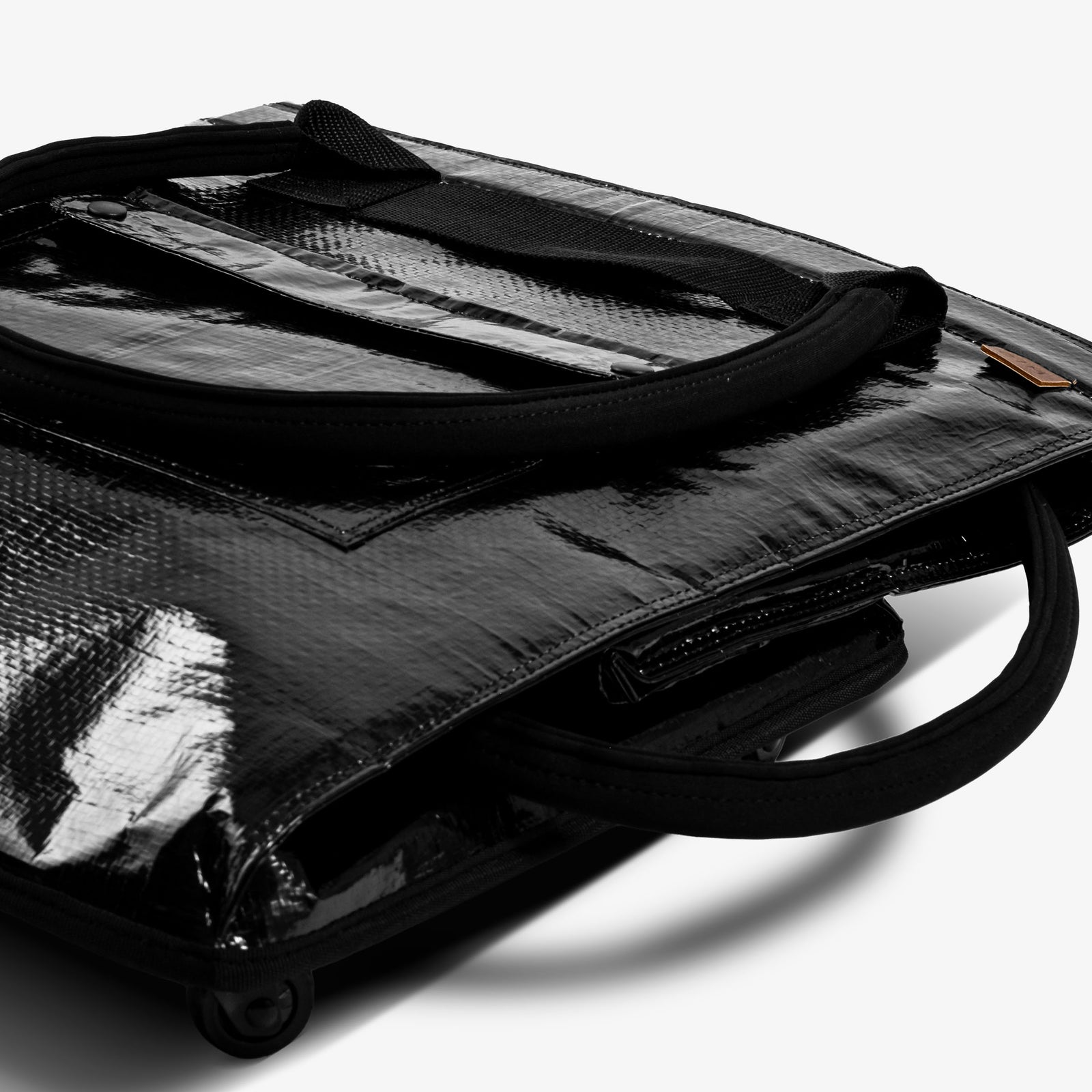 Black garment on a rolling dolly with wheels on a white background