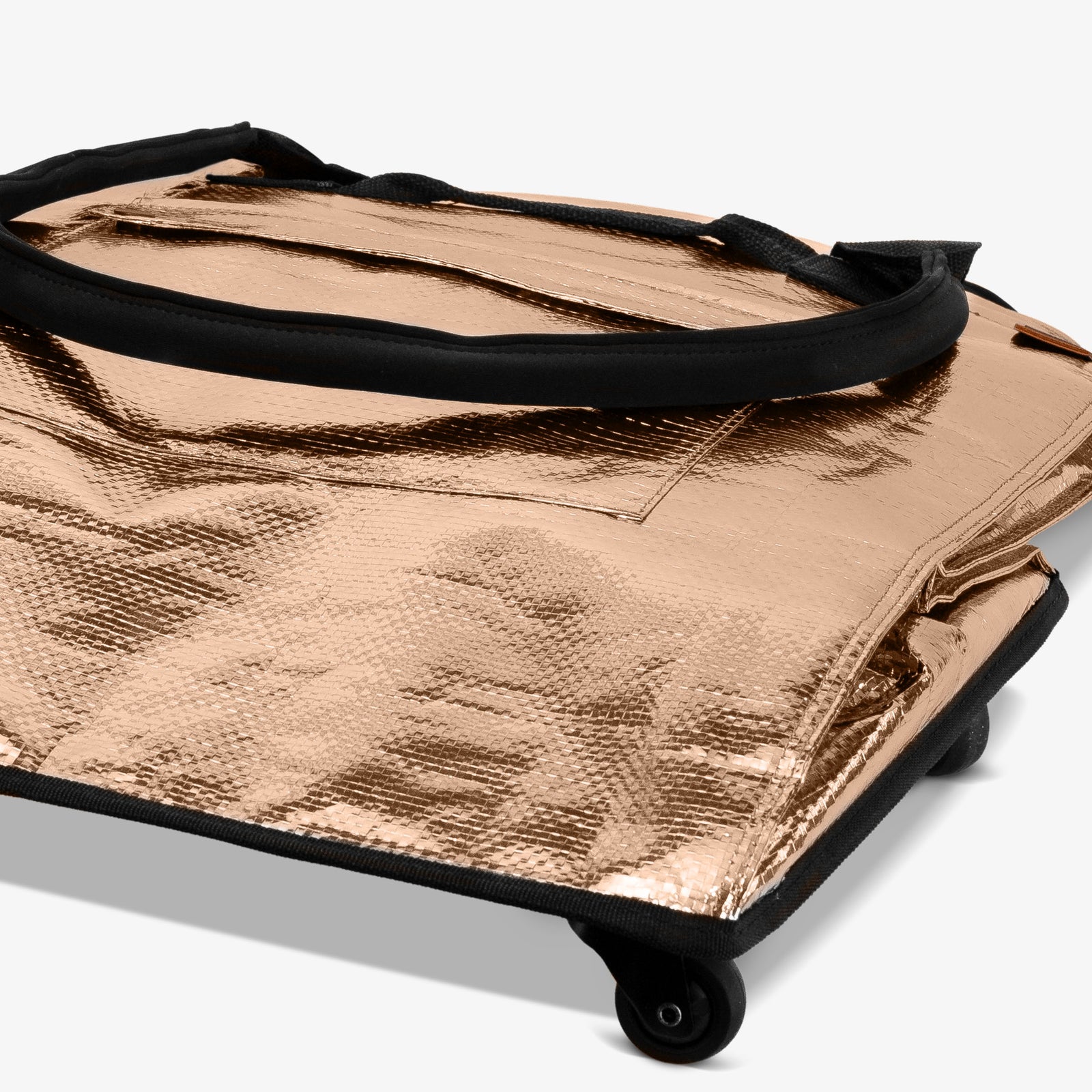 Metallic gold bag with black handle on a white background