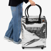 A lady Holding Silver Rolling Hauler Bag With Rollers While Walking