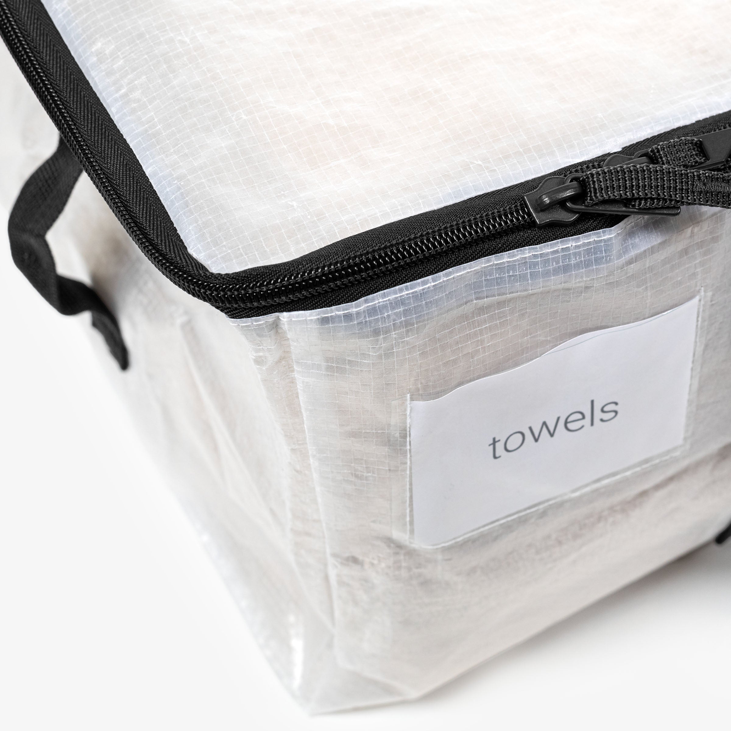 Clear travel bag with black zipper and 'towels' label on a white background