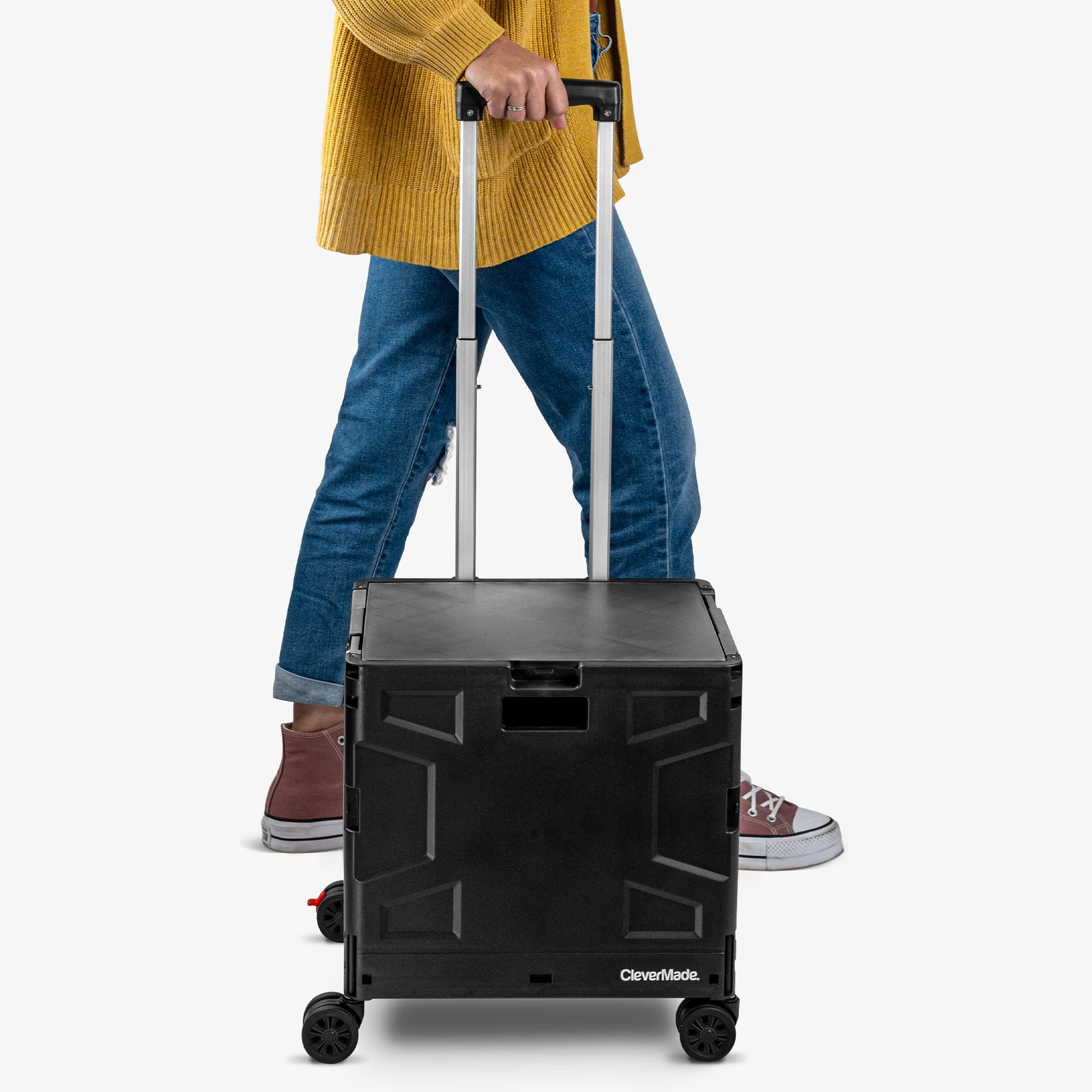 Person pushing a black CleverMade rolling cart on a white background